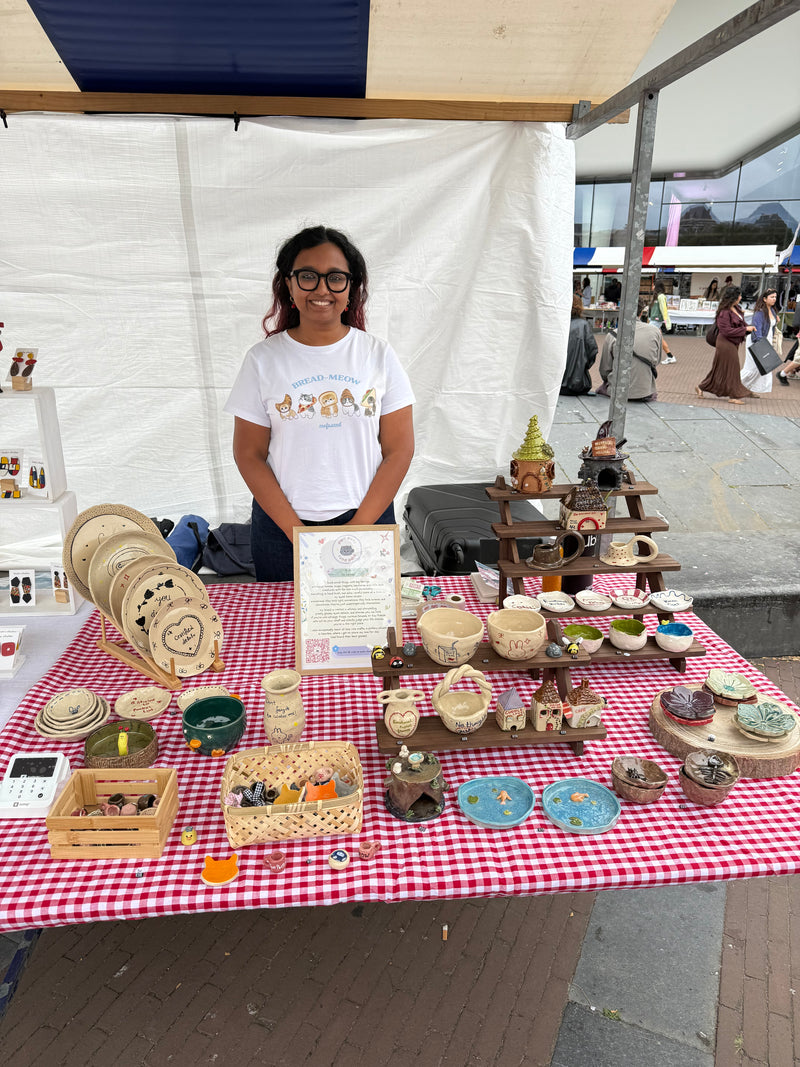 Ceramic artist selling handmade pottery at a local market in the Netherlands