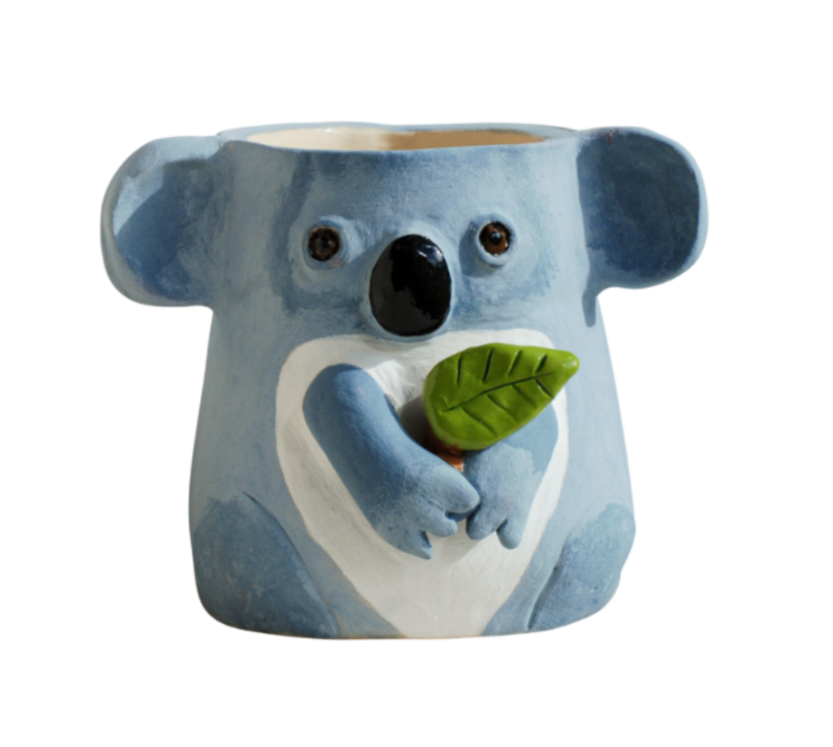 A ceramic planter shaped like a blue koala holding a green eucalyptus leaf, set against a plain white background.