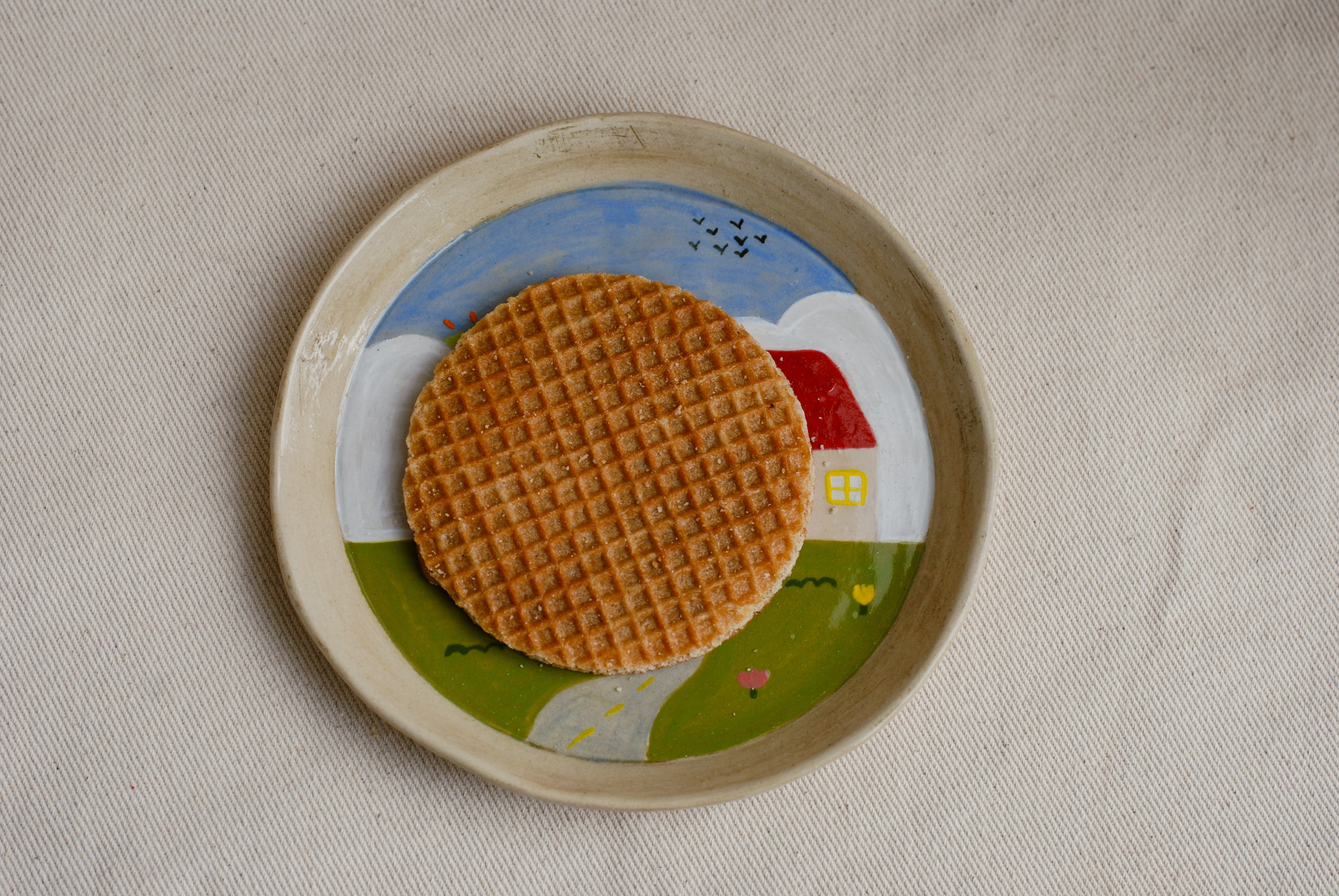 whimsical ceramic plate with countryside landscape artwork