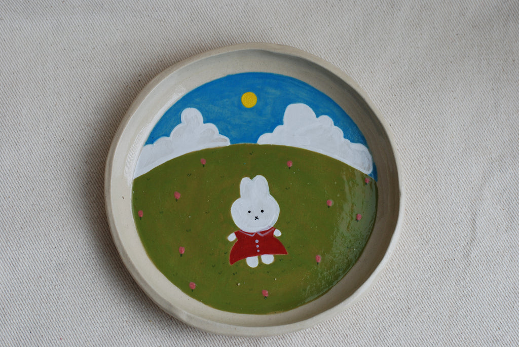 handmade ceramic plate with hand-painted bunny in flower meadow, whimsical stoneware netherlands