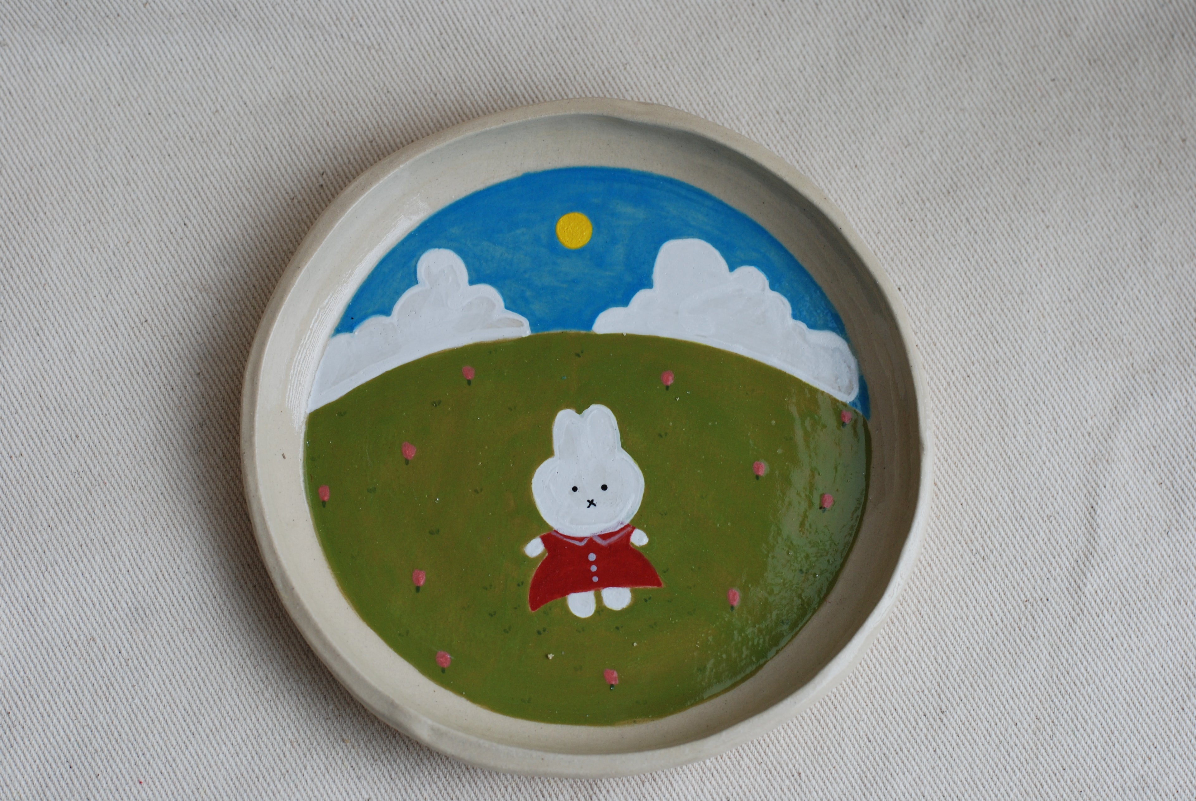 handmade ceramic plate with hand-painted bunny in flower meadow, whimsical stoneware netherlands