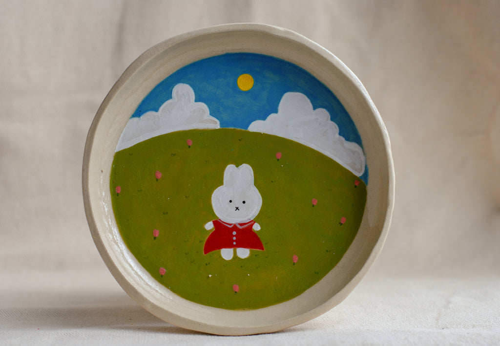 handmade ceramic plate with hand-painted bunny in flower meadow, whimsical stoneware netherlands