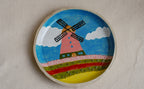 hand-painted stoneware plate featuring a dutch landscape