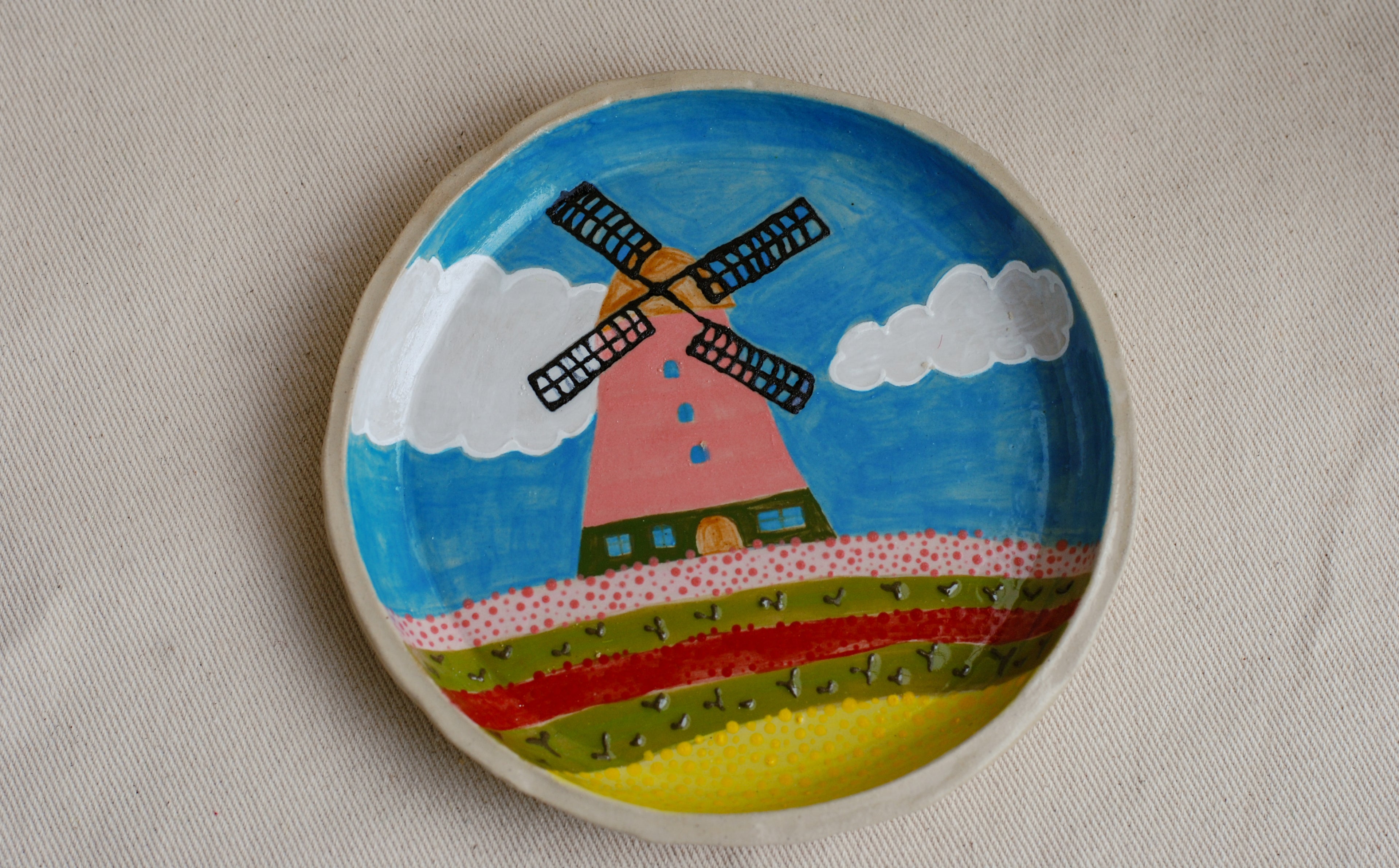 hand-painted stoneware plate featuring a dutch landscape