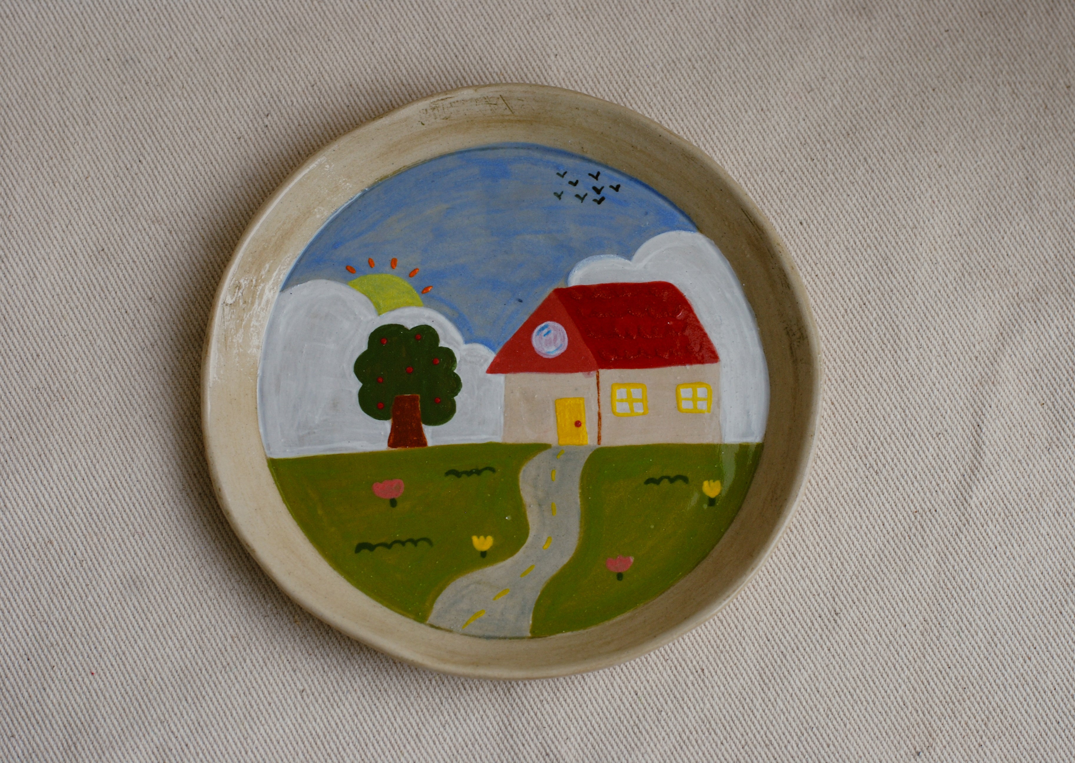 hand-painted stoneware plate featuring a red roof house