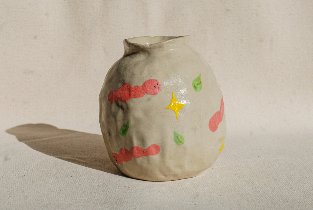 Ceramic vase with colorful decorations on a beige background